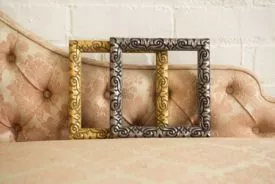 two picture frames standing on a piece of furniture